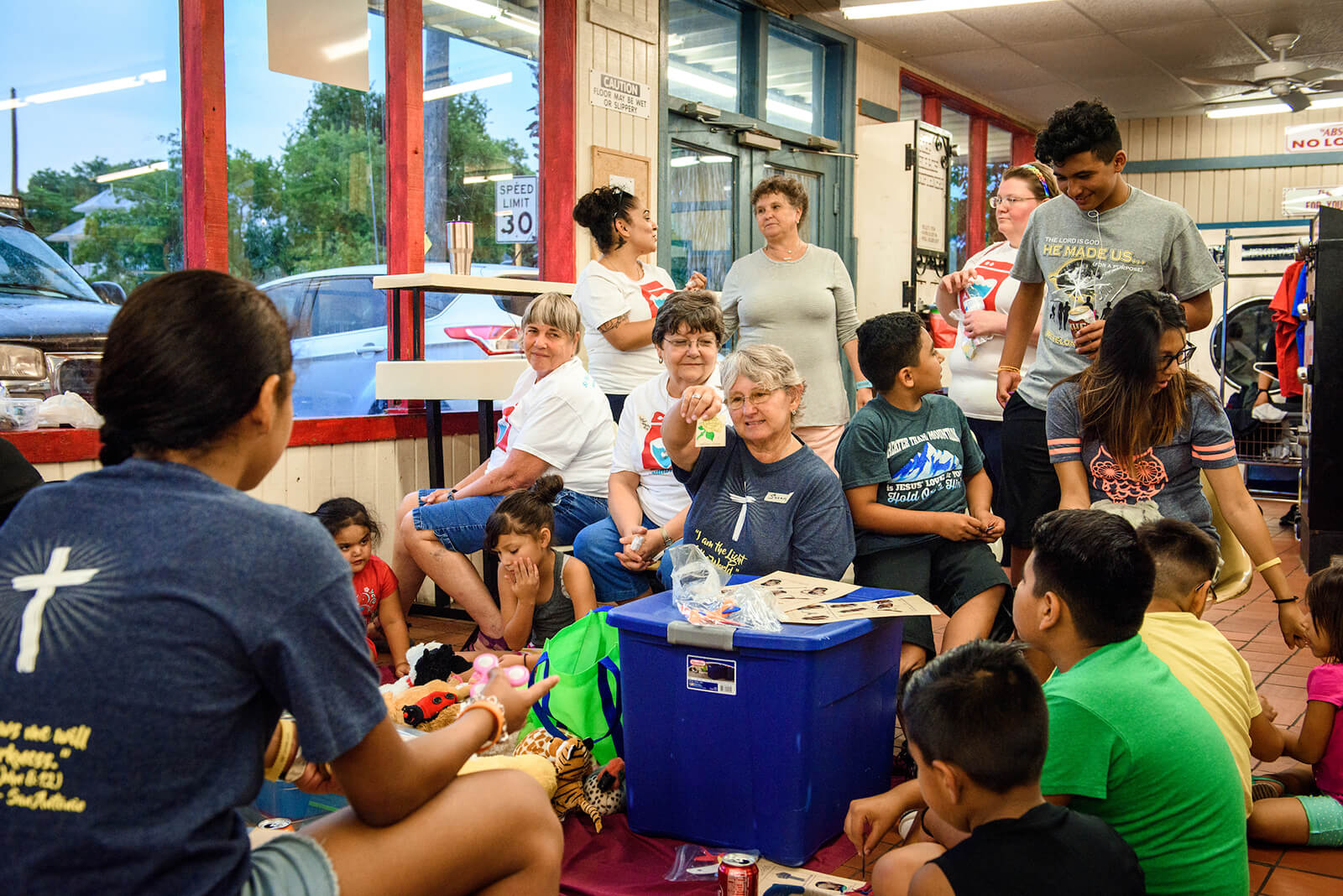 Volunteers from St. Paul Lutheran Church, San Antonio, hold a mini Sunday school lesson for children at August's Laundry Love event.