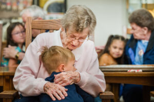 Resident Ella Pennington hugs Kase Daniels from Acorns and Oaks Christian Academy as the children visit LCMS congregation members and other residents of the Spring Valley Campus of Perry Lutheran Homes on Wednesday, May 21, 2025, in Perry, Iowa. LCMS Communications/Erik M. Lunsford